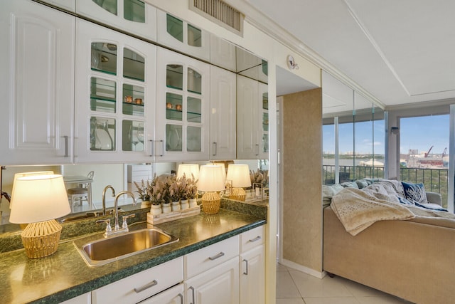 kitchen with light tile patterned flooring, sink, and white cabinetry