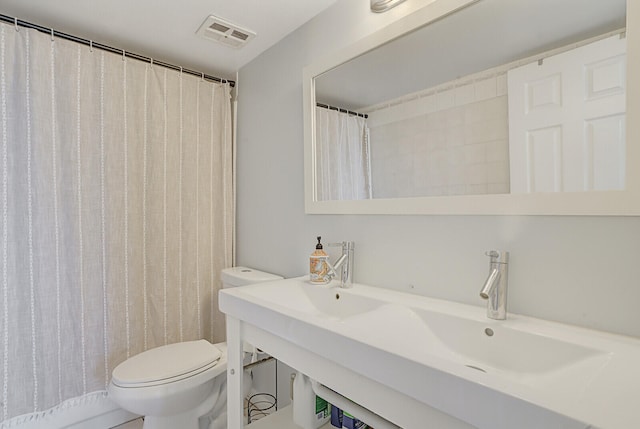 bathroom with curtained shower and toilet