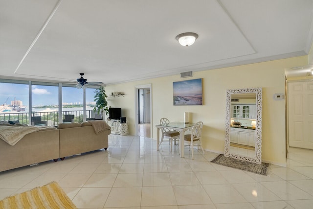 living room with ceiling fan, a wall of windows, crown molding, and light tile patterned floors