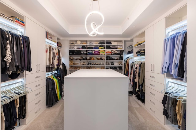 walk in closet featuring light colored carpet and a tray ceiling