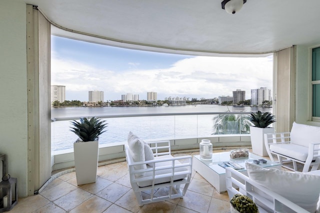 exterior space with outdoor lounge area, a balcony, and a water view