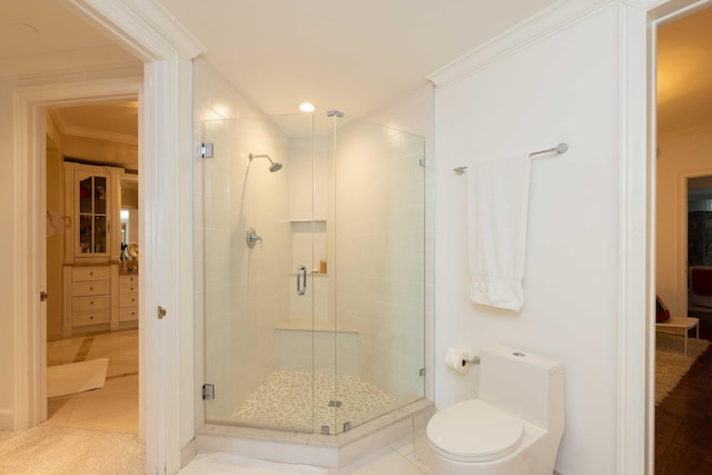 bathroom with ornamental molding, tile patterned flooring, a shower with door, and toilet