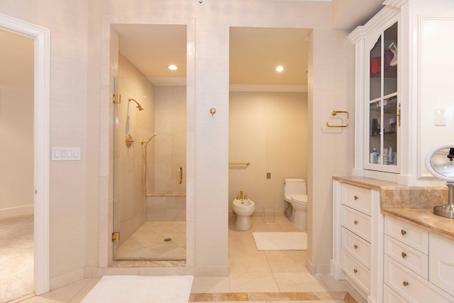 bathroom with vanity, toilet, a bidet, walk in shower, and tile patterned flooring