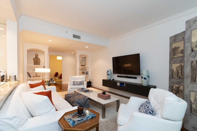 living room featuring built in shelves, ornamental molding, and hardwood / wood-style flooring