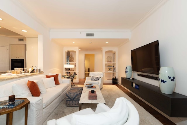 living room with hardwood / wood-style flooring and crown molding