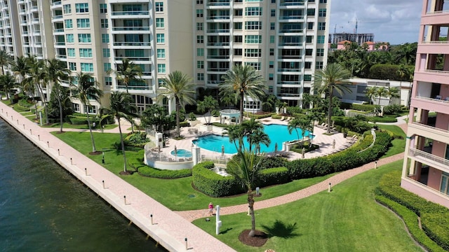 view of swimming pool featuring a water view and a yard