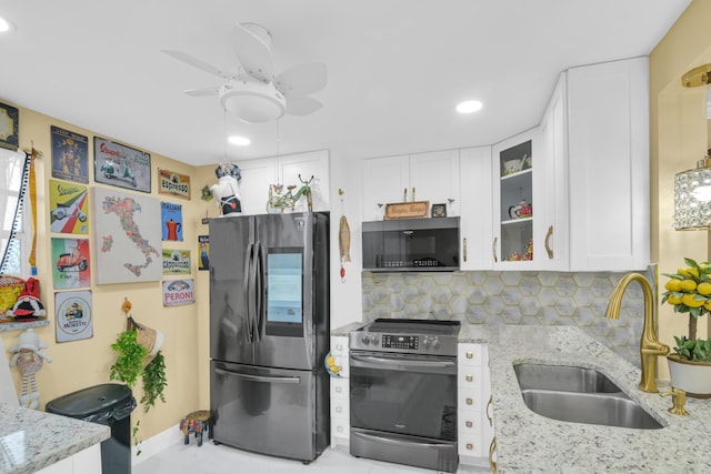 kitchen with light stone counters, sink, white cabinetry, decorative backsplash, and stainless steel appliances