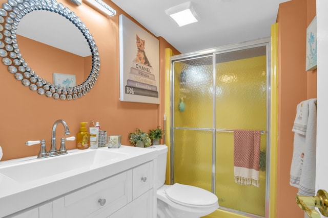 bathroom with vanity, a shower with shower door, and toilet