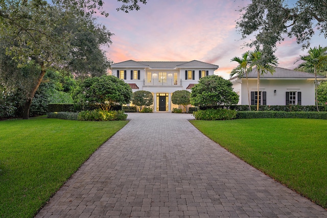 view of front of property with a lawn and a balcony