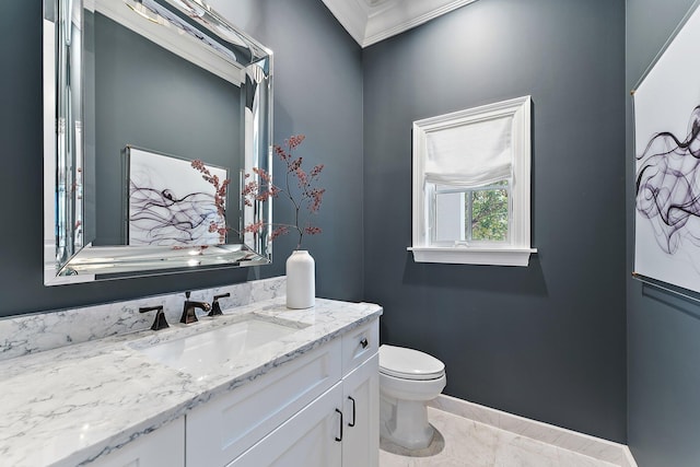 bathroom with toilet, vanity, and ornamental molding