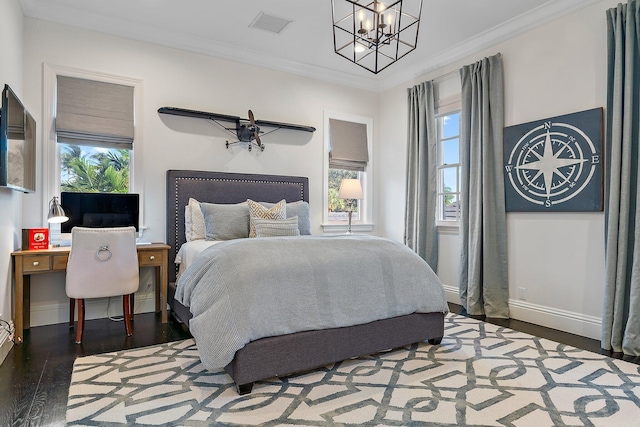 bedroom featuring hardwood / wood-style flooring, a chandelier, and ornamental molding