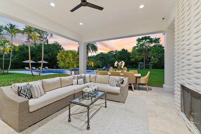 patio terrace at dusk with ceiling fan and an outdoor living space