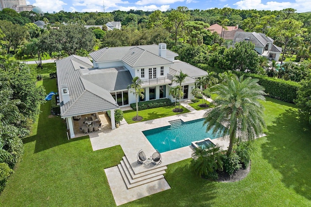 view of swimming pool with exterior kitchen, a bar, a lawn, and a patio