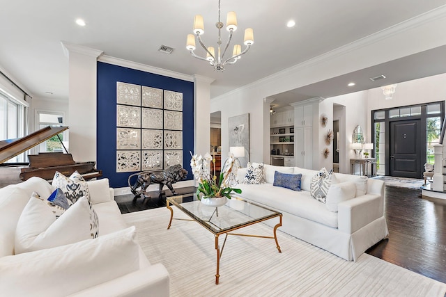 living room with hardwood / wood-style flooring, ornamental molding, and a chandelier