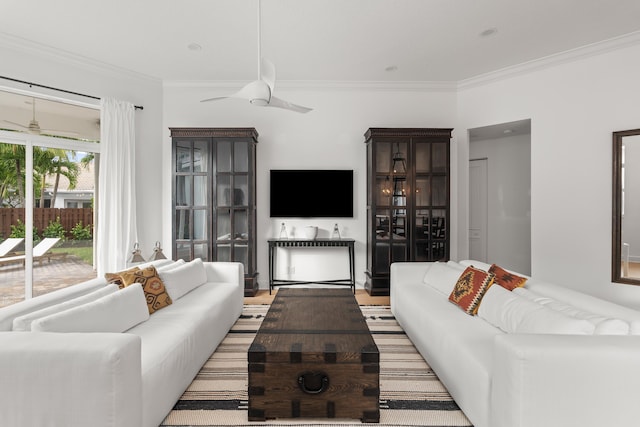 living room with light hardwood / wood-style flooring, ceiling fan, and crown molding