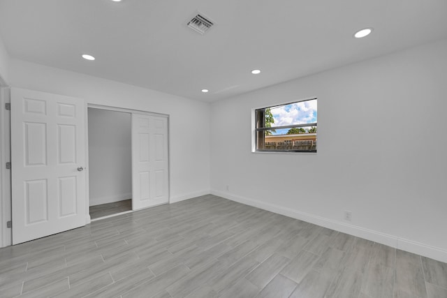 unfurnished bedroom with a closet and light wood-type flooring