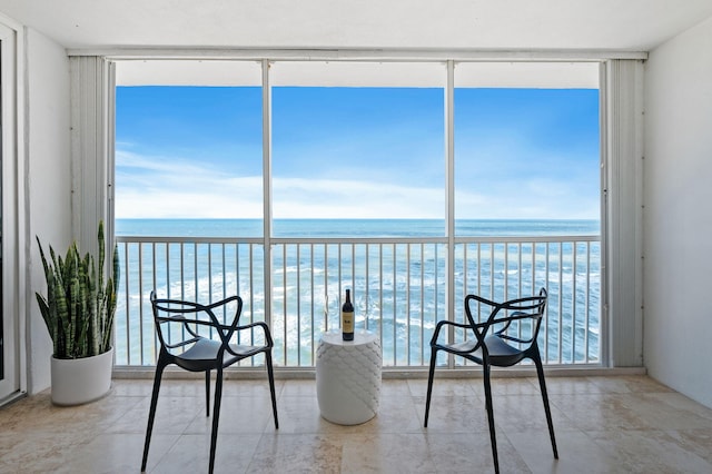 sunroom featuring a water view