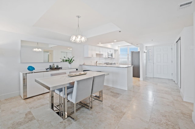 kitchen with a kitchen island, a breakfast bar area, kitchen peninsula, pendant lighting, and white cabinetry