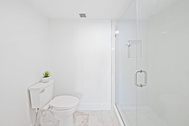 bathroom with toilet, a shower with shower door, and tile patterned flooring