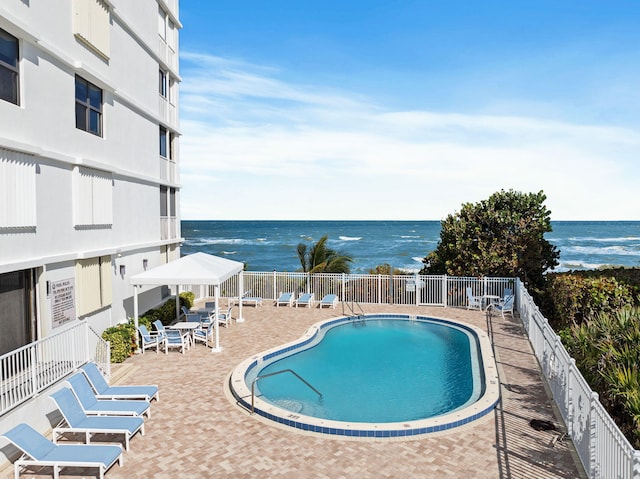 view of swimming pool with a patio and a water view