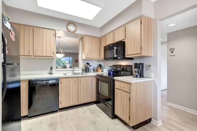 kitchen with pendant lighting, sink, light brown cabinets, and black appliances