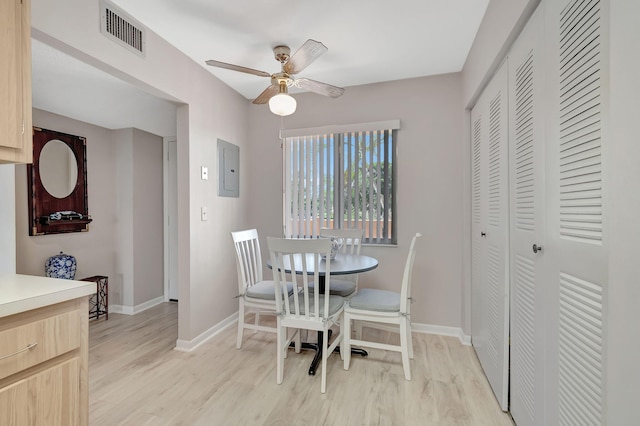 dining room with ceiling fan, electric panel, and light hardwood / wood-style floors