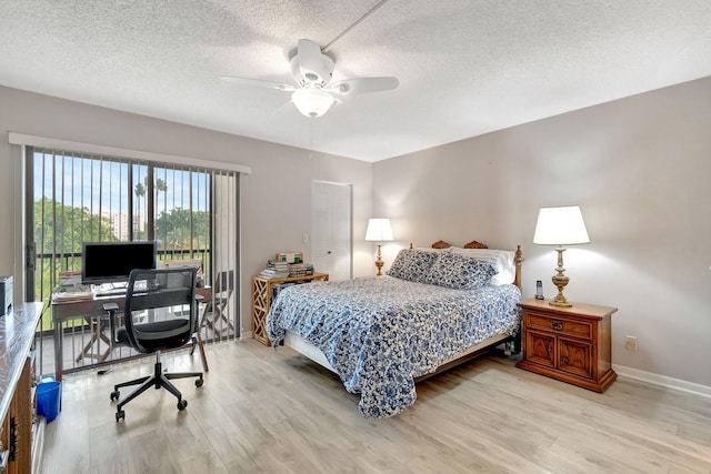 bedroom with ceiling fan, light hardwood / wood-style floors, and a textured ceiling