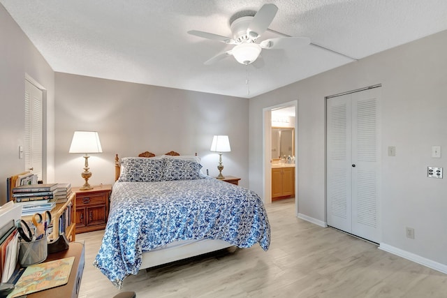 bedroom with ensuite bath, a textured ceiling, a closet, ceiling fan, and light hardwood / wood-style floors