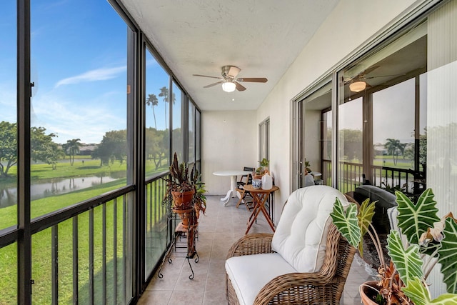 sunroom / solarium featuring ceiling fan, a healthy amount of sunlight, and a water view