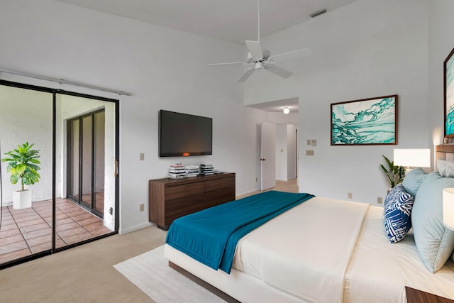 bedroom featuring access to outside, a towering ceiling, light carpet, and ceiling fan