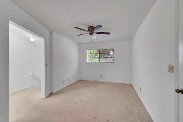 carpeted empty room with ceiling fan and a textured ceiling