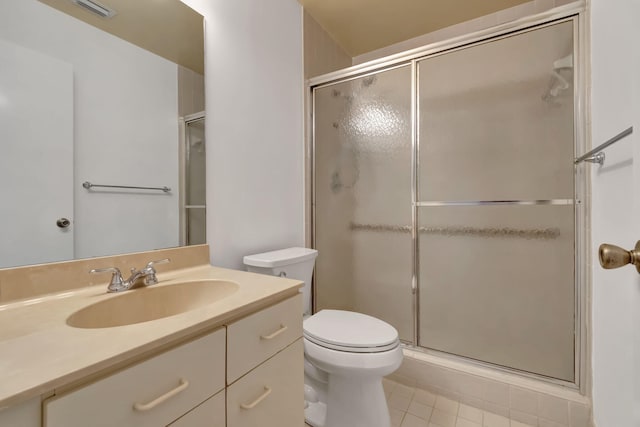 bathroom with vanity, tile patterned flooring, toilet, and a shower with door