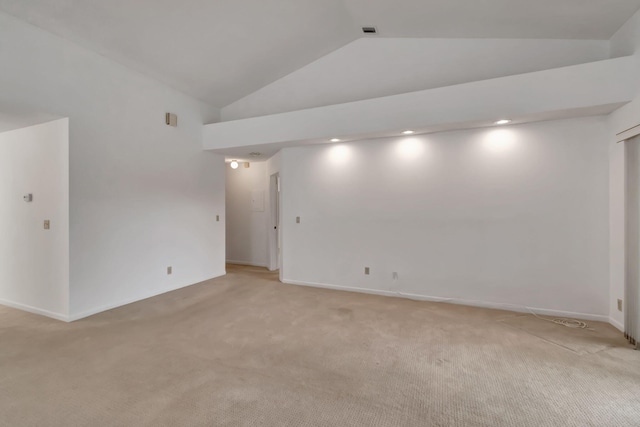 empty room featuring light colored carpet and lofted ceiling