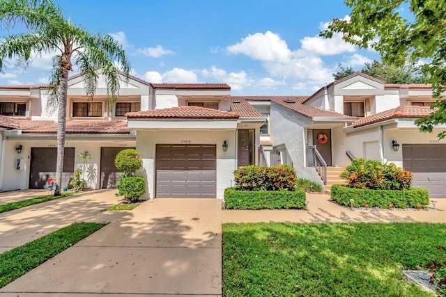 mediterranean / spanish house with a garage and a front lawn