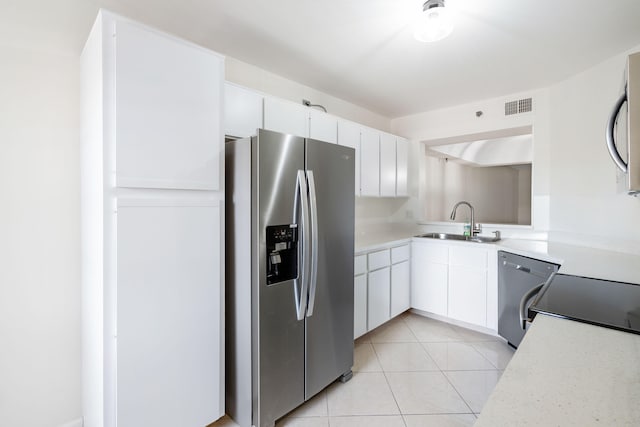 kitchen with light tile patterned flooring, white cabinetry, sink, and stainless steel appliances