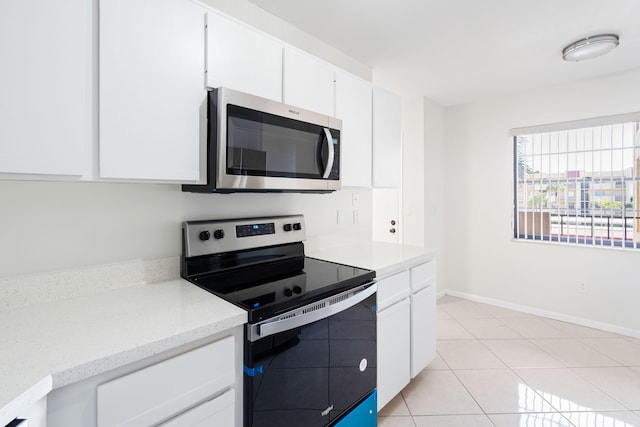 kitchen featuring white cabinets, appliances with stainless steel finishes, and light tile patterned flooring