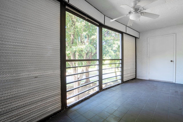 unfurnished sunroom with ceiling fan