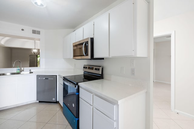 kitchen featuring white cabinetry, appliances with stainless steel finishes, hanging light fixtures, and sink