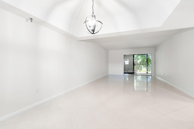 spare room with light tile patterned flooring and a chandelier