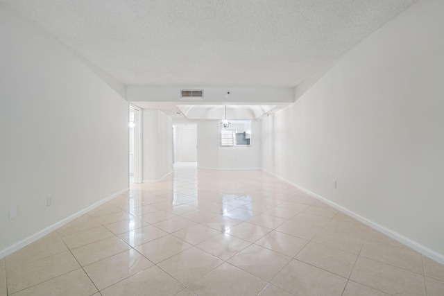 unfurnished room featuring a textured ceiling and light tile patterned floors