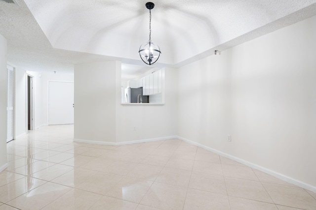 unfurnished room featuring a notable chandelier, a textured ceiling, and light tile patterned floors