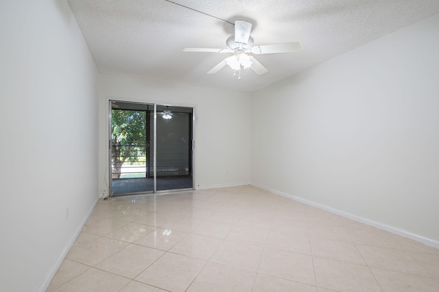 unfurnished room featuring a textured ceiling, light tile patterned flooring, and ceiling fan