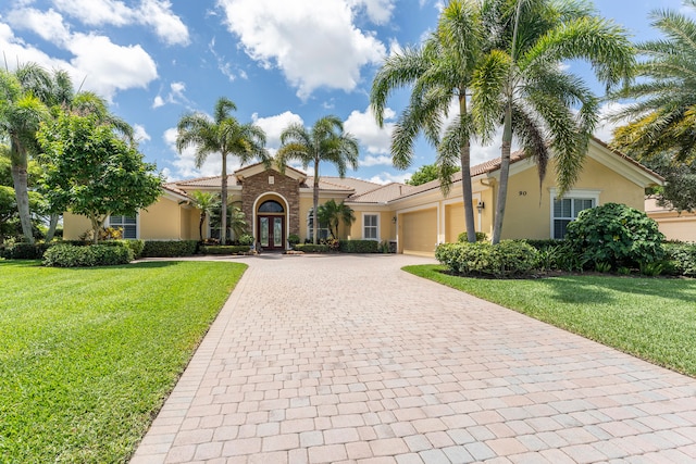 mediterranean / spanish-style house with a front yard and a garage