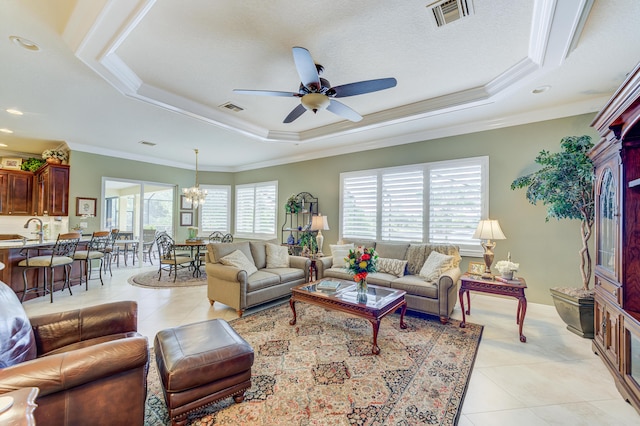 tiled living room featuring ornamental molding, a tray ceiling, and a healthy amount of sunlight