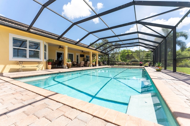 view of pool featuring glass enclosure and ceiling fan