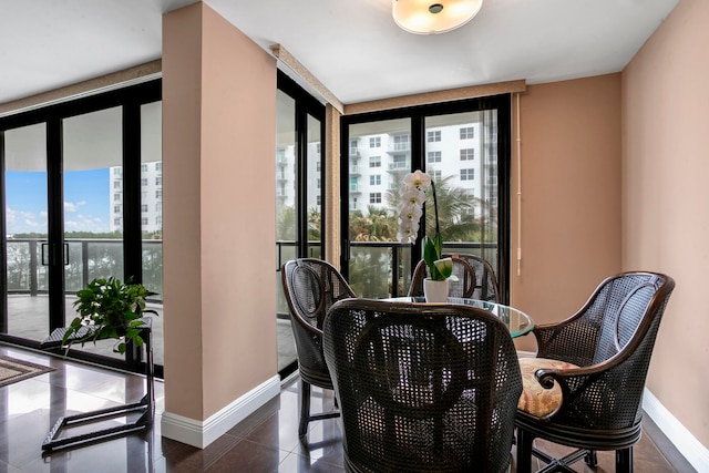 living area featuring dark tile patterned flooring, expansive windows, and a healthy amount of sunlight