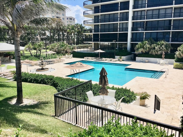 view of pool featuring a lawn and a patio