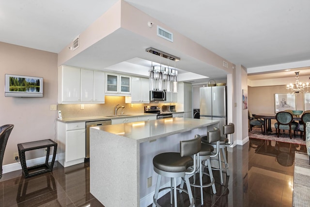 3440 S Ocean Blvd Unit S 401, Palm Beach, FL 33480 - kitchen with stainless steel appliances, a sink, baseboards, white cabinets, and a center island