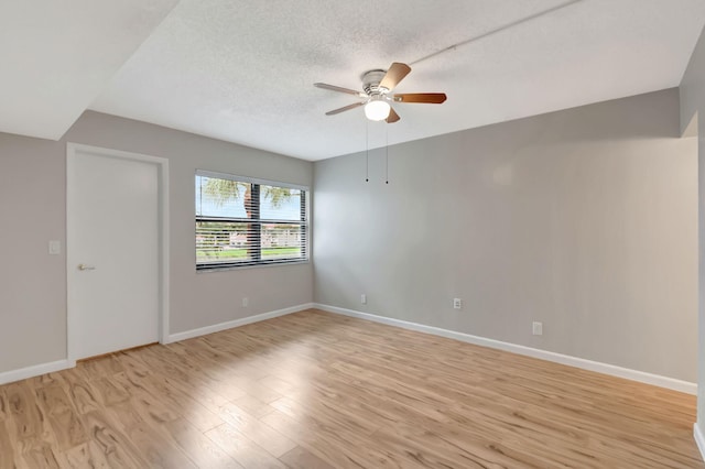 spare room featuring ceiling fan, light hardwood / wood-style floors, and a textured ceiling