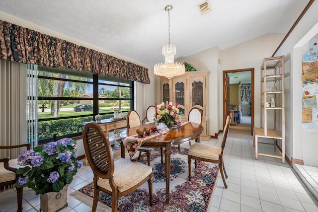 tiled dining area with a textured ceiling, lofted ceiling, and an inviting chandelier